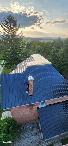Aerial view of a blue standing-seam roof at sunset