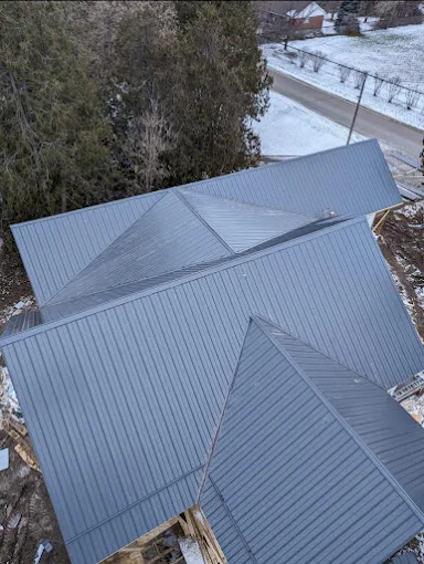 Aerial view of a grey standing-seam steel multi-hip roof