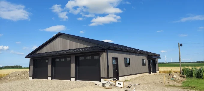 Completed charcoal post-frame home with attached triple-bay garage