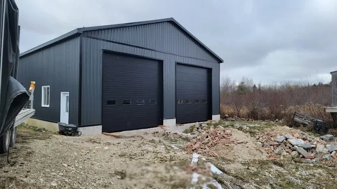 Dark grey post-frame garage with two large overhead doors